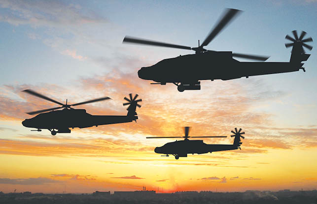 Silhouette of helicopters over sunset