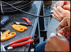 A black and orange machine with a screen on a wooden table. Description generated by AI