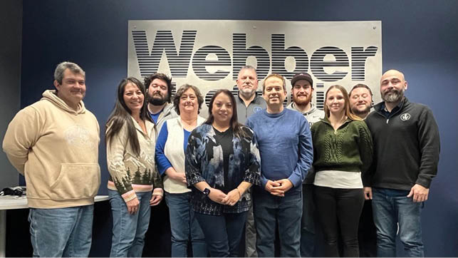 A group of people posing for a photo in front of a sign that says “weber". AI generated content
