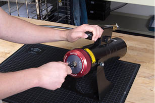 A person is working on a machine, possibly a drill, with a red wheel. AI generated content
