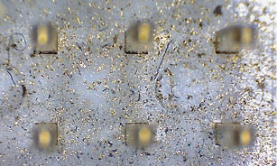 The image shows a close-up of a piece of gold jewelry, possibly a ring, with a few small stones on it. The gold appears to be tarnished, giving it a worn and aged appearance. AI generated content