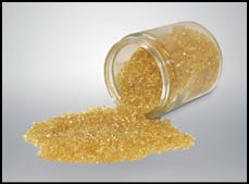 A glass container with yellow powder inside. Description generated by AI