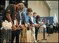 A group of people cutting a ribbon. Description generated by AI