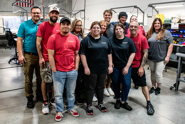 A group of people wearing red shirts and black shirts. Description generated by AI