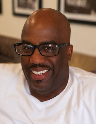 A man wearing glasses and a white shirt. Description generated by AI