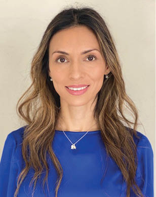 A woman wearing a blue shirt and a necklace. Description generated by AI