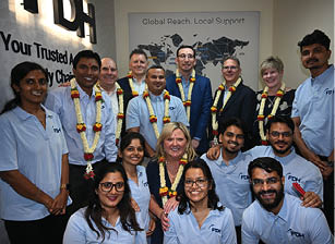 A group of people wearing necklaces and posing for a picture. Description generated by AI