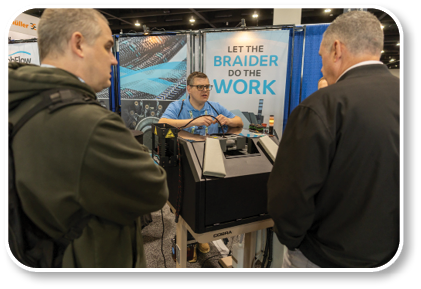 A man is showing a machine to two other men. Description generated by AI