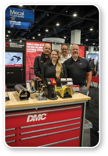 A group of people standing in front of a red and black DMC toolbox. Description generated by AI