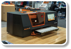 A black and orange machine with a red light on top. Description generated by AI