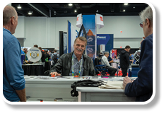 A man is sitting at a desk in a room. Description generated by AI