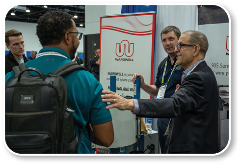 A man in a blue shirt is talking to another man in a suit. Description generated by AI