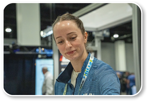 A woman wearing a blue shirt with a name tag. Description generated by AI