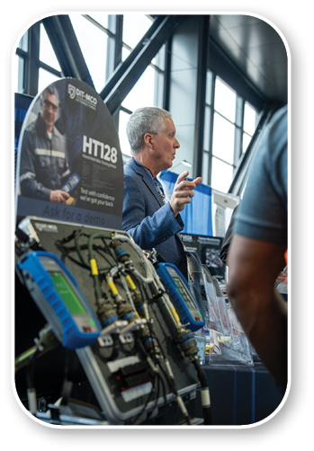 A man is standing in front of a table with a sign that says HT22. Description generated by AI