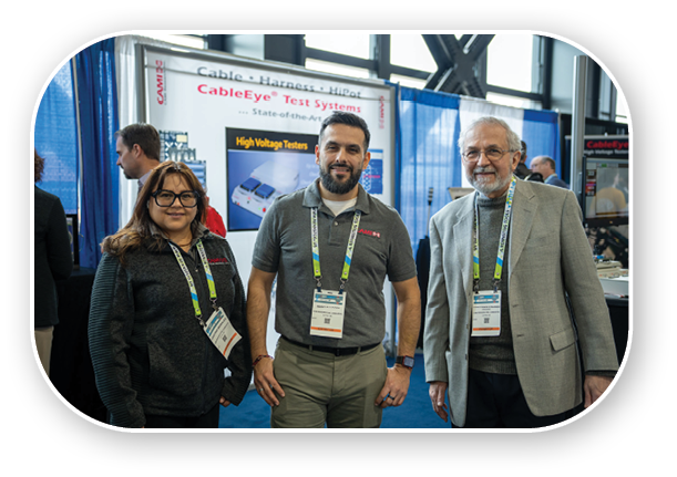 Three people standing in front of a display. Description generated by AI