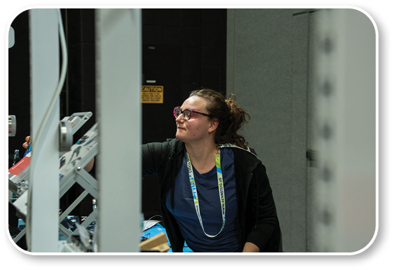 A woman wearing glasses and a lanyard. Description generated by AI
